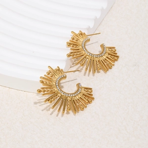 Detail of 18K gold-plated sunray earrings with white micro-stones on geometric stand