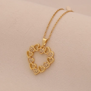 Elegant gold heart pendant necklace with micro-pave cubic zirconia on soft beige fabric
