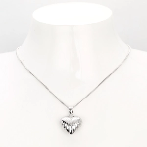 Macro view of a silver S925 heart pendant with striped relief on a thin O-chain