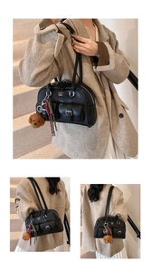 Bolso Boston vintage negro con bolsillos frontales y dije de oso de peluche en modelo