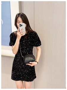 Close-up of black acrylic shell clutch bag with vertical ridges and chain strap