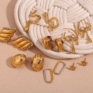 Close-up of 18K gold plated earrings with colorful zircons and geometric liquid metal design