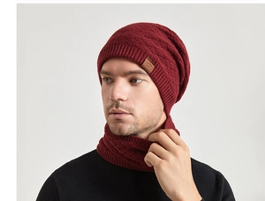 Close-up of wine red knitted beanie and scarf set with thick twill texture and leather tag
