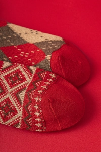 Détail macro de chaussettes en laine rouge montrant la texture du tricotage