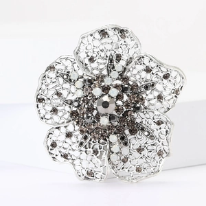 Detail of silver hollow flower brooch with sparkling clear and black rhinestones