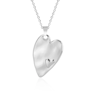 Macro shot of silver tiered heart pendant on a cable chain over white background