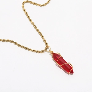 Close-up of bohemian gold twisted chain necklace with hand-wrapped red crystal pendant