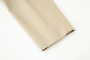 Detail shot of khaki trench coat cuff showing high-quality twill texture and double stitching
