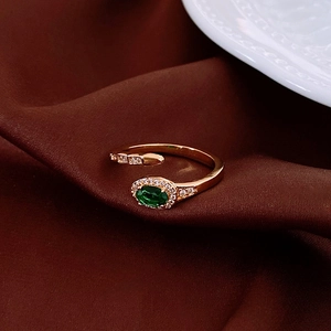 Macro shot of French vintage gold ring featuring a green oval zircon on brown velvet