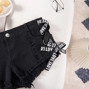 Dettaglio di pantaloncini di denim neri a vita alta con nastro LOVE e orlo a vivo