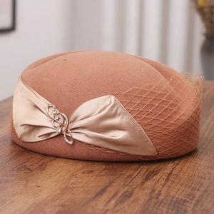 Detail of wool beret with mesh veil, ribbon bow and crystal treble clef charm
