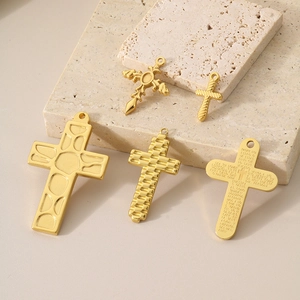 Macro shot of assorted golden titanium steel cross pendants with Spanish Lord's Prayer
