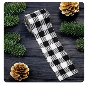 Detail of buffalo plaid ribbon with pine cones on dark wood for Christmas decor