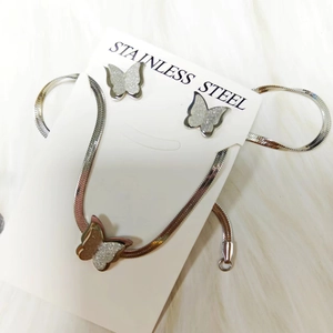 Detailed macro of silver stainless steel butterfly jewelry set with textured glitter finish