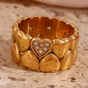 Detail of 18K gold-plated heart ring with micro-set zircon stones on stone surface