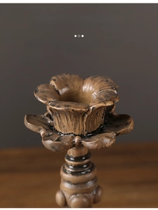 Close-up of vintage floral resin candle holder with antique bronze finish and petal texture