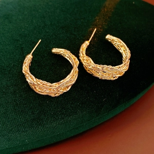 Close-up of 18K gold plated C-shape hoop earrings with twisted metallic texture