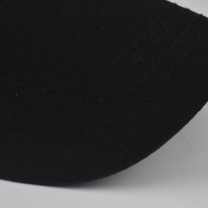 Detail of parallel stitching and black cotton twill texture on a baseball cap brim