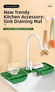 Close-up of green silicone kitchen sink mat with drainage grooves and storage compartments
