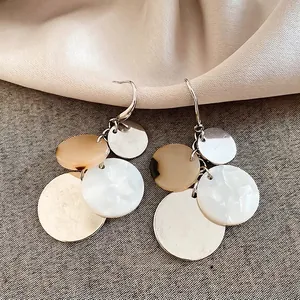 Acrylic geometric layered disc tassel earrings on silk fabric for a summer beach vacation