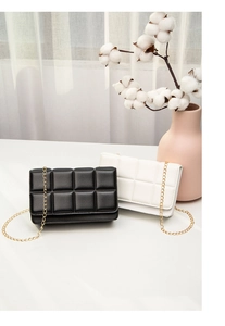 Detail of checkered quilted leather small crossbody bags in black and white colors