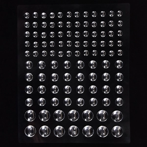 Macro view of transparent self-adhesive silicone bumper pads on a black background