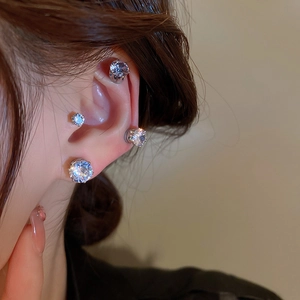 Macro shot of silver magnetic zircon clip-on earrings worn on lobe and cartilage