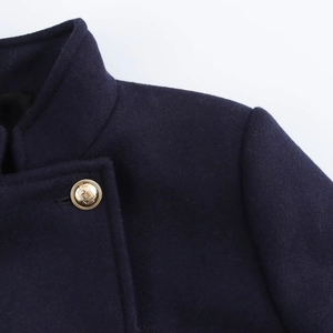 Close-up of navy blue wool blend coat featuring premium texture and embossed gold buttons