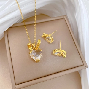Elegant gold rabbit ear heart pendant necklace and stud earrings set on white silk