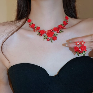 Detail of red rose and green leaf necklace with golden chain on female model