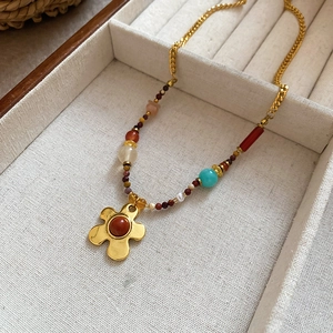 Macro view of retro beaded flower necklace featuring tiger eye stones and golden petals
