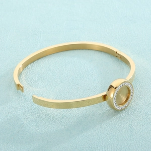 Macro detail of gold DIY bangle with a diamond-encrusted round bezel setting