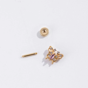 Detail of gold butterfly cartilage earring with pink and clear zircon butterfly wings