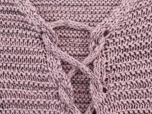 Close-up of lilac knitwear showing cross-lace neckline detail and textured weaving