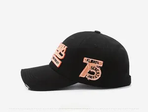 Detail of orange 3D embroidery and vintage distressed brim on black cotton baseball cap
