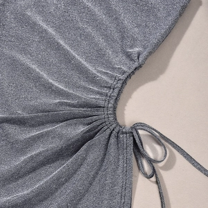 Détail du tissu métallique argenté scintillant avec cordon de serrage et plis ruchés