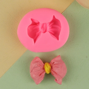 Detail of 3D bow silicone fondant mold for chocolate and DIY clay crafting with finished product