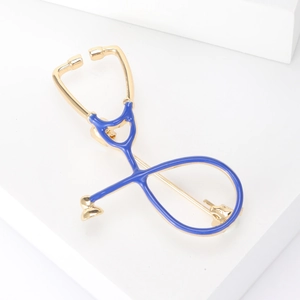 Close-up of a gold stethoscope brooch with blue enamel detailing for medical professionals