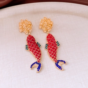 Close-up of koi fish tassel earrings with red enamel scales and blue rhinestone detail