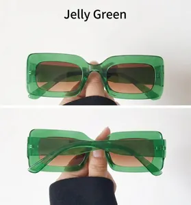 Detail view of jelly green rectangular sunglasses with wide temples and brown lenses