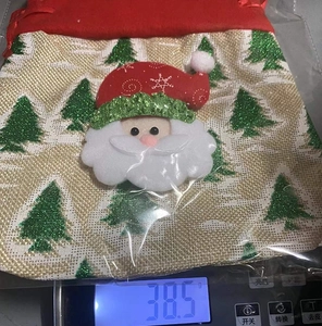 Detailed view of burlap Christmas gift bag weighing 38.5g on a digital scale