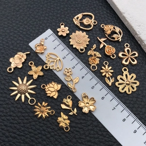 Macro shot of assorted KC gold sunflower and rose charms with scale for size reference