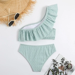 Detailed flat lay of mint green ruffled one-shoulder bikini with high-waisted bottoms