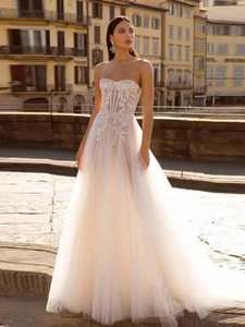 Détail du corsage en dentelle blanche et jupe en tulle d'une robe de mariée bustier