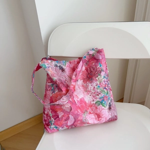 Detailed shot of vibrant pink floral shoulder bag hanging on a white minimalist chair