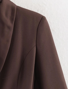 Detailed view of dark brown satin splicing and shoulder stitching on a blazer