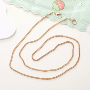 Detail of a thin gold metal chain strap featuring secure lobster clasps on both ends