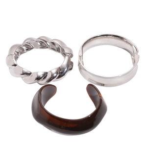 Minimalist silver metal bangles and amber resin cuff set shown on a white background