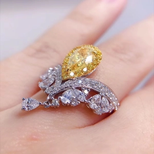 Luxurious silver crown ring featuring a large yellow pear-cut carbon diamond and white stones