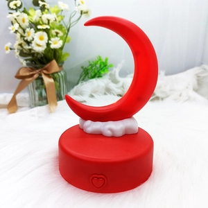 Detail of red crescent moon night light with cloud base and heart-shaped power button